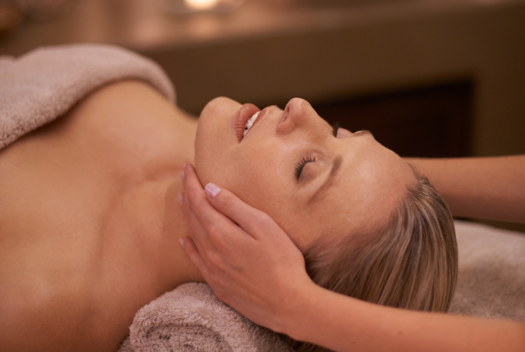 Attractive, blonde woman relaxes during an upper body massage
