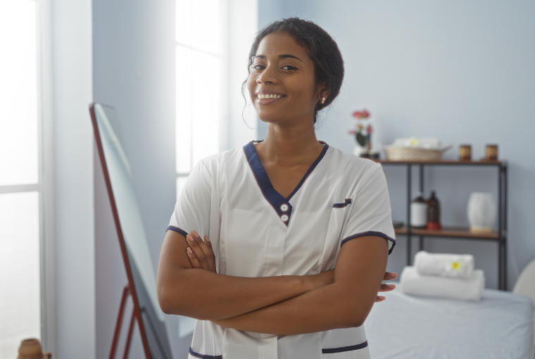Young, smiling spa owner stands proudly in front of the camera